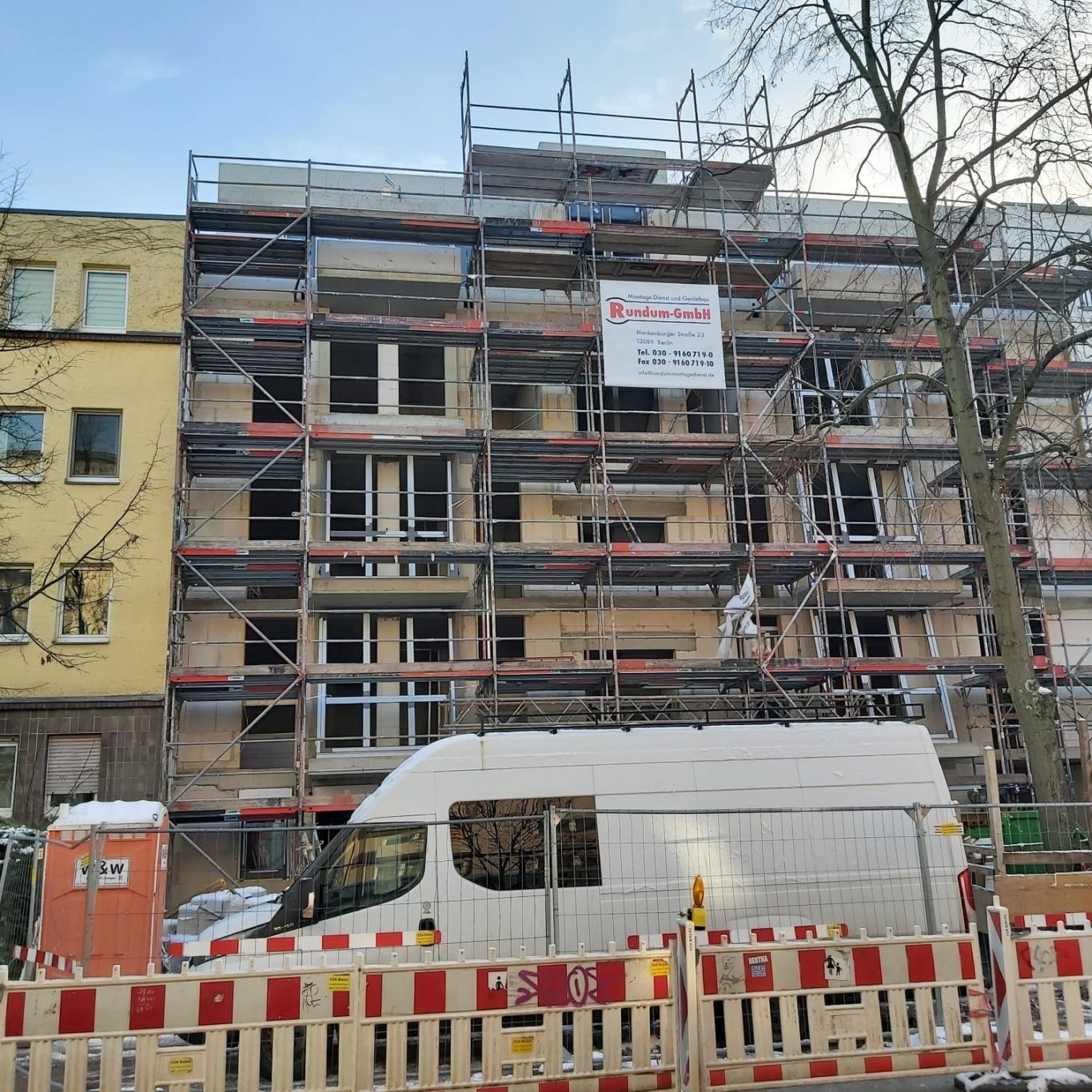 BV: Neubau, Eichborndamm 54, 13403 Berlin in Bauphase Baugerüst um ein Wohngebäude mit Bauarbeiten und einem weißen Lieferwagen davor.